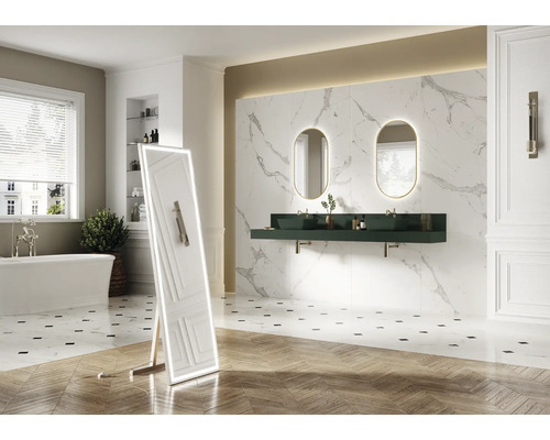 Badkamer met bad, wastafel, spiegels en tegels met marmerlook