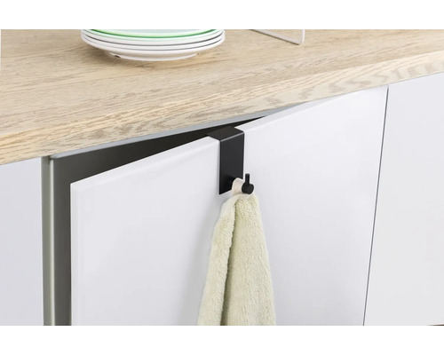 Zwarte deurhaak met handdoek aan een keukendeur