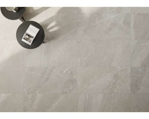 Lichte vloertegels met marmerlook gelegd, met tafel en boek.