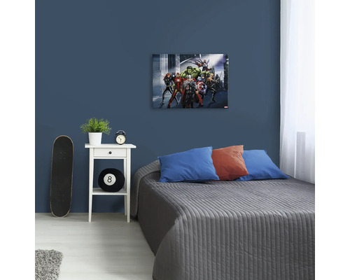 Woonkamer met bed en muurdecoratie van de Avengers
