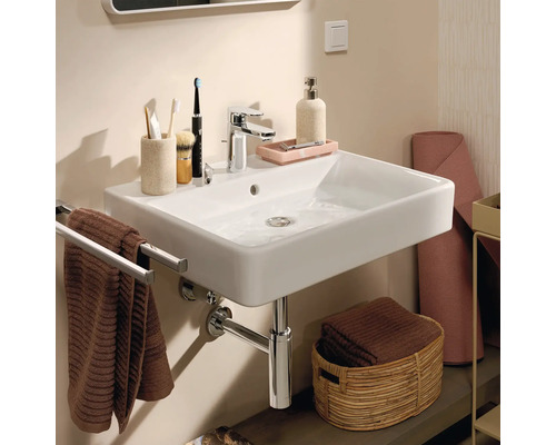 Foto van een badkamer met een wastafel, een kraan, een handdoekenrek en badkameraccessoires.