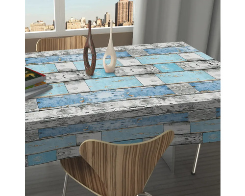 Tafel met tafelkleed in houtdesign in een lichte ruimte.