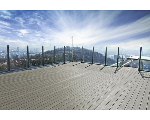 Terras met houten planken en glazen balustrade met uitzicht op de stad
