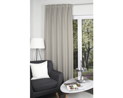 Decoratief gordijn naast fauteuil en tafel in een woonkamer