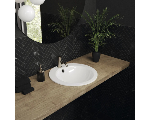 Badkamer met ronde wastafel, kraan, houten werkblad en zwarte wandbekleding in visgraatmotief