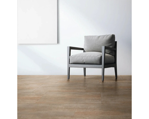 Lichte ruimte met vloertegels, fauteuil en een schilderij aan de muur