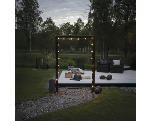 Tuin met houten terras, zitplaatsen en lichtslinger voor een gezellige sfeer