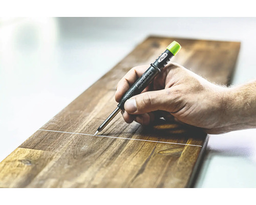 Een hand trekt een lijn op een houten plank met een Pica Longlife Automatic Pencil.