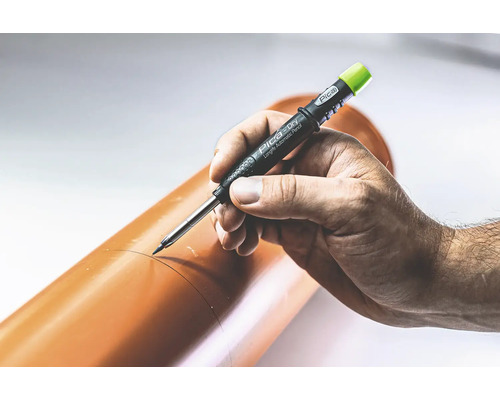 Een hand markeert een bruine buis met een Pica Dry Longlife Automatic Pencil.