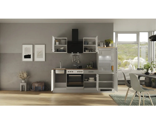 Complete inbouwkeuken met elektrische apparaten, afzuigkap en koelkast in een lichte ruimte