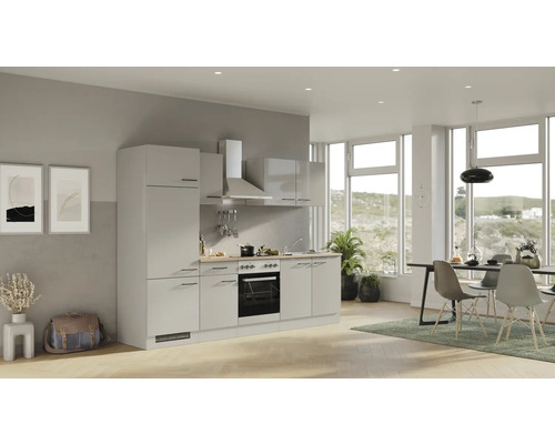 Lichte keuken met inbouwkasten, afzuigkap en eetgedeelte in een lichte, moderne ruimte.