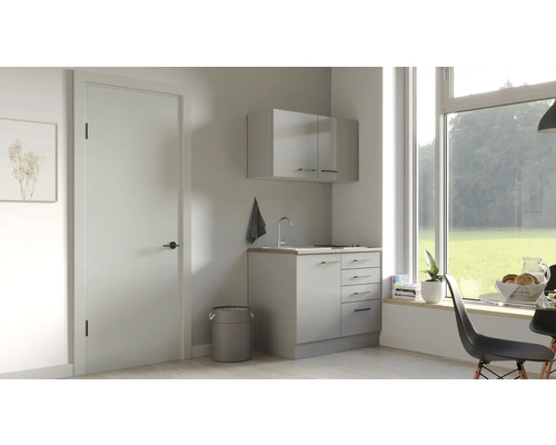 Lichte wasruimte met wastafel, onderkast en hangkast onder een groot raam.