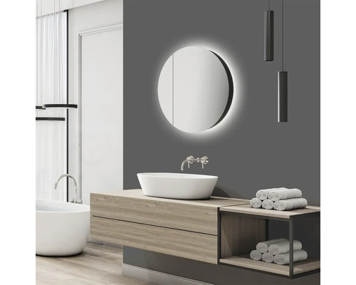 Moderne badkamer met ronde spiegelkast, wastafel en bad.