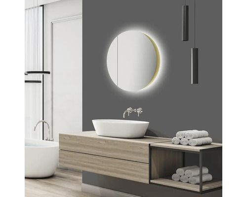 Badkamer met wastafel, ronde spiegel met verlichting en handdoeken