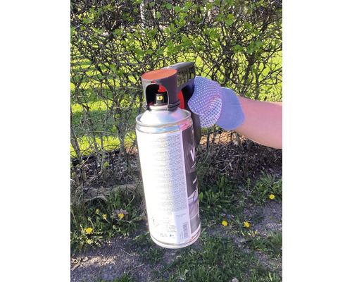 Spuitbus met spuitpistool in de hand