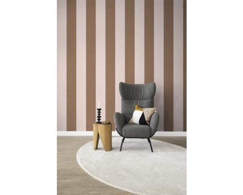 Woonkamer met gestreept behang, fauteuil, bijzettafel en tapijt