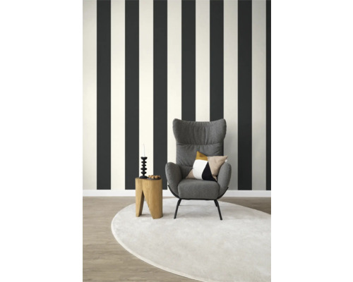 Woonkamer met gestreept behang, fauteuil en rond vloerkleed