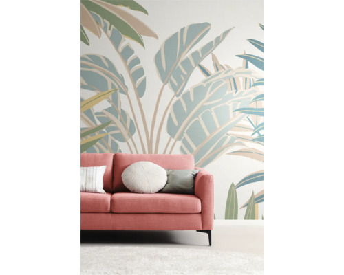 Woonkamer met roze bank voor een muur met plantenpatroon