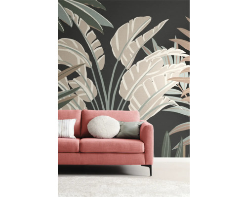 Woonkamer met koraalkleurige bank voor een muur met bloemenbehang.