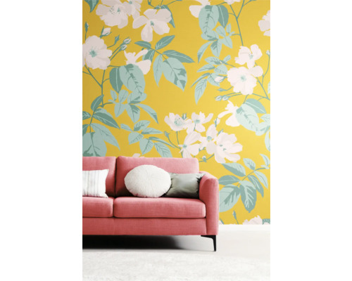 Kamer met roze bank voor een muur met bloemmotief