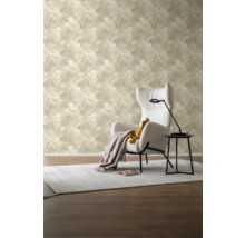 Woonkamer met beige behang met palmmotief, fauteuil en bijzettafel.
