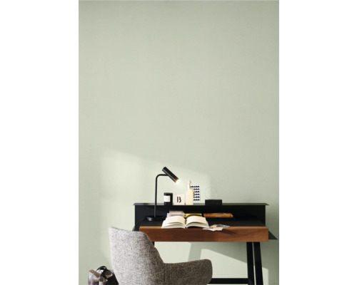 Werkkamer met bureau, lamp en stoel voor lichtgroene wand