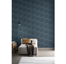 Woonkamer met blauw geometrisch patroonbehang, fauteuil, staande lamp en vloerkleed