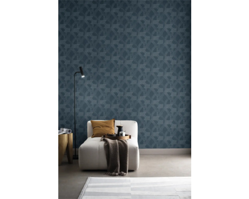 Woonkamer met blauw geometrisch patroonbehang, fauteuil, staande lamp en vloerkleed