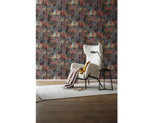 Woonkamer met patroonbehang, fauteuil, staande lamp en vloerkleed voor een gezellige sfeer