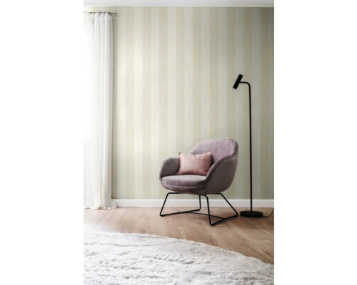 Woonkamer met gestreept behang, fauteuil en staande lamp