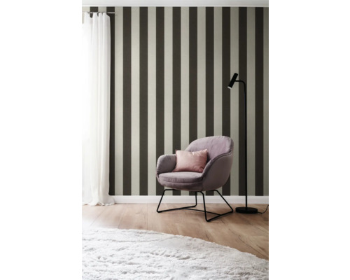 Interieuridee met gestreept behang, fauteuil en staande lamp voor een stijlvolle sfeer.