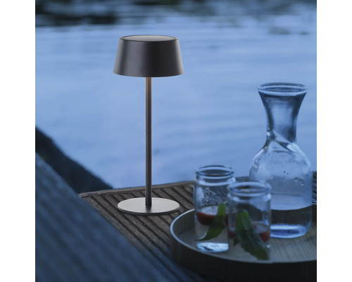 Decoratieve tafellamp naast karaf en glazen buiten