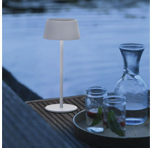 Decoratieve ambiance met tafellamp, waterkaraf en glazen buiten