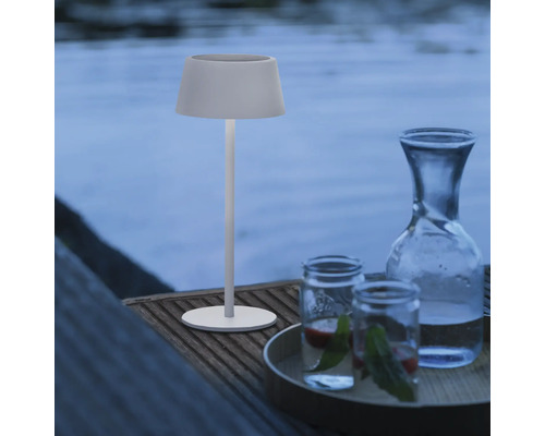 Decoratieve ambiance met tafellamp, waterkaraf en glazen buiten