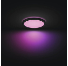Ronde LED-plafondlamp met zwart frame, plat ontwerp, geeft roze licht.
