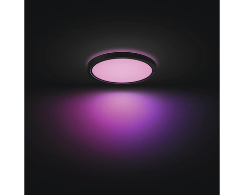 Ronde LED-plafondlamp met zwart frame, plat ontwerp, geeft roze licht.