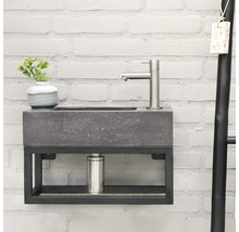 Wastafel met grijze wastafelblad, kraan en zwart metalen frame voor een bakstenen muur