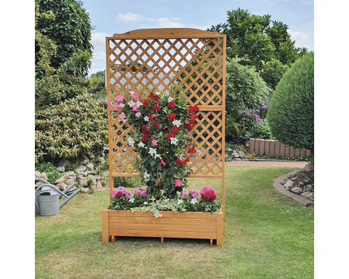 Houten plantenbak met klimrek en bloeiende planten in de tuin