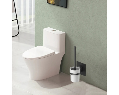 Wit staand toilet met toiletborstel aan de muur