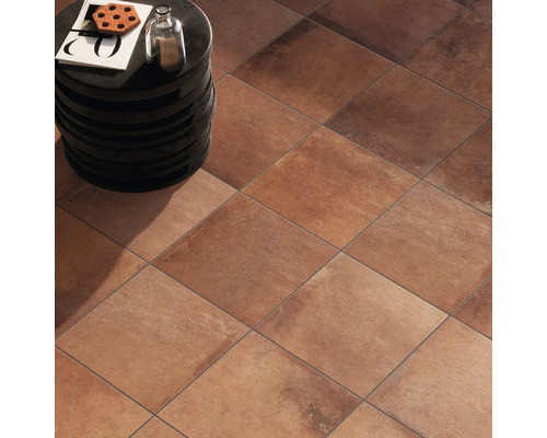 Vloeraanzicht met vierkante terracotta tegels en een klein bijzettafeltje