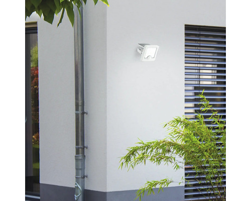 Witte buitenlamp aan een huismuur gemonteerd.