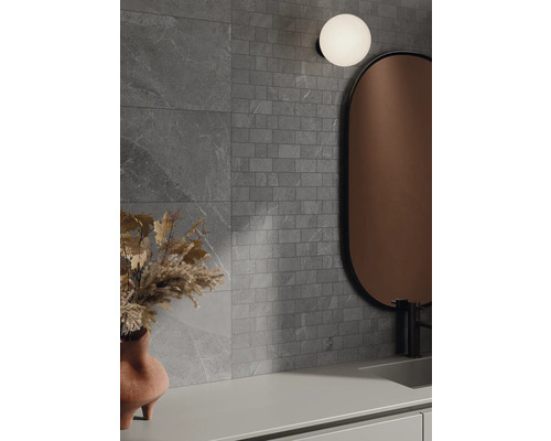 Badkamer met grijze tegels, spiegel en lamp