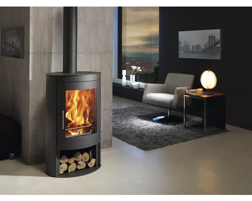 Woonkamer met houtkachel, fauteuil en decoratie voor een gezellige sfeer