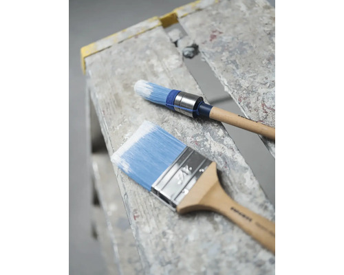 Twee penselen met houten handgrepen op een ladder