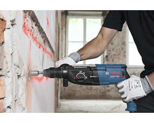 Ambachtsman boort een gat in een muur met een boorhamer