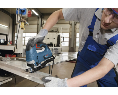 Ambachtsman aan het werk met een decoupeerzaag om metaal te snijden.