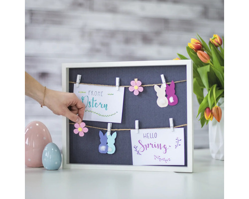 Decoratie met paas- en lentemotieven op een bord met wasknijpers.