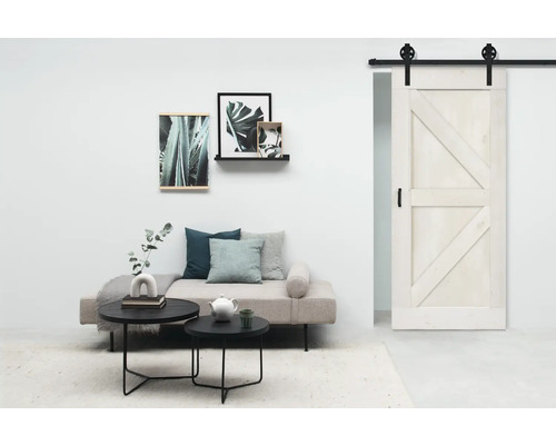 Woonkamer met schuifdeur, bank, salontafels en wanddecoraties voor een moderne sfeer.