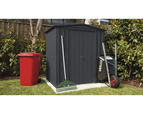 Tuinscene met tuinhuis, vuilnisbak, kruiwagen en hark buiten.