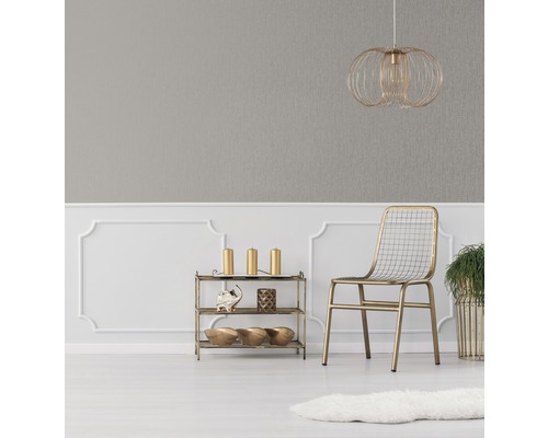 Decoratieve ruimte met grijs behang, gouden lamp, stoel en rek